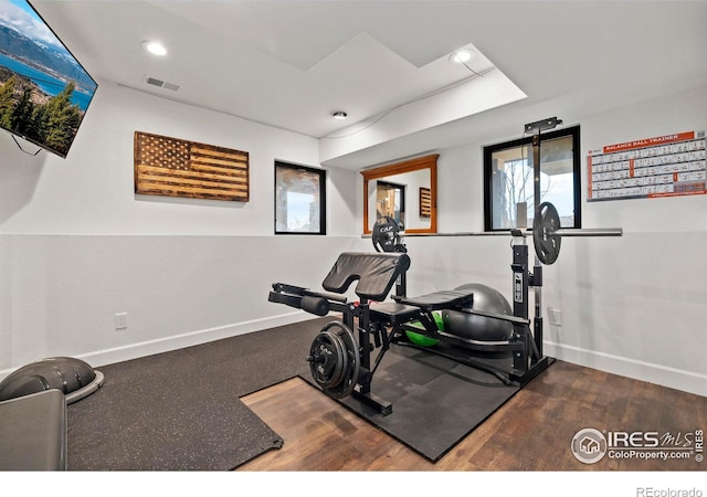 exercise room featuring baseboards, visible vents, wood finished floors, and recessed lighting