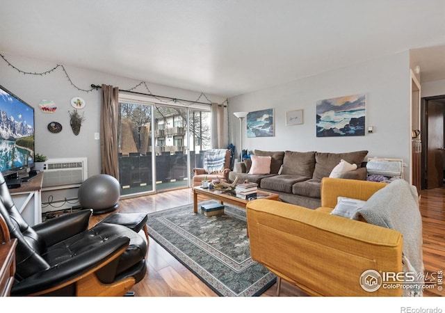 living room featuring a wall mounted air conditioner and wood-type flooring