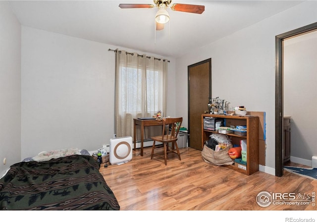 interior space with hardwood / wood-style floors, ceiling fan, and baseboard heating