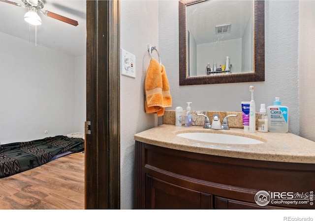 bathroom with hardwood / wood-style flooring, vanity, and ceiling fan