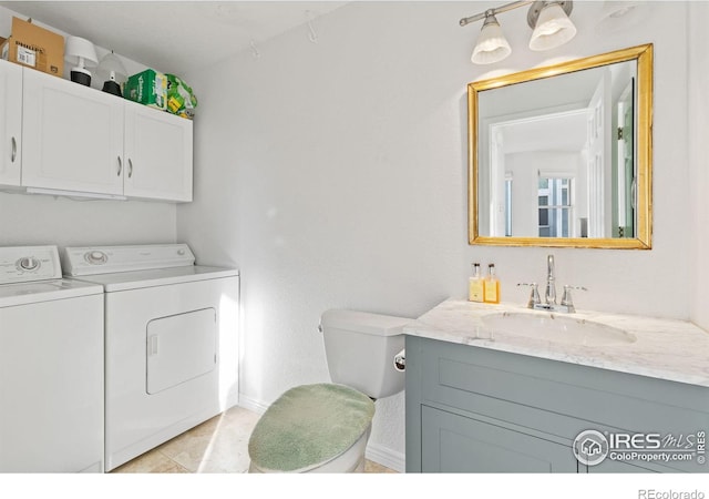 washroom featuring light tile patterned floors, washing machine and dryer, and sink