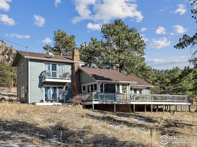 back of property with a balcony and a wooden deck