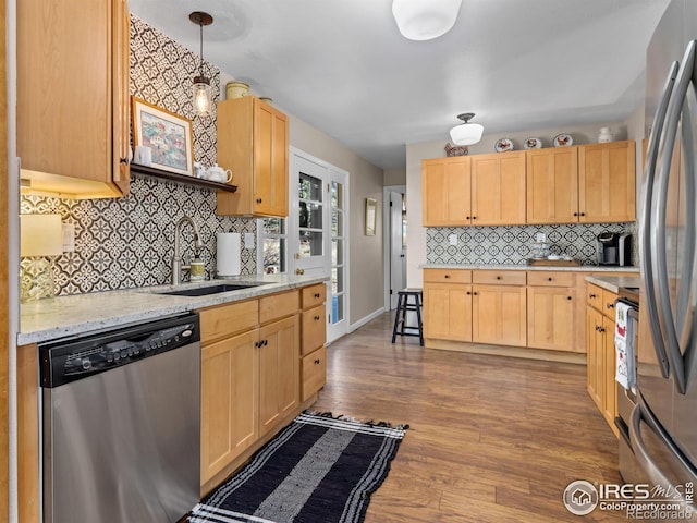 kitchen with decorative light fixtures, sink, stainless steel appliances, and light brown cabinetry