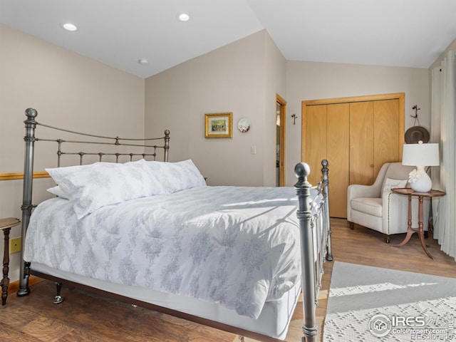 bedroom featuring hardwood / wood-style flooring, a closet, and lofted ceiling