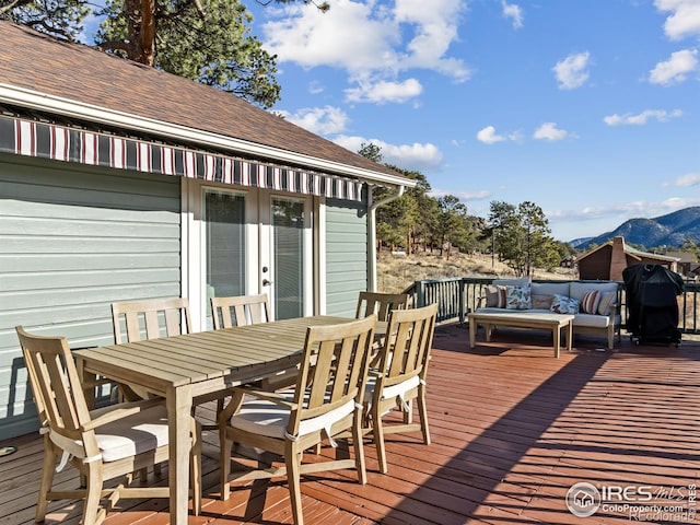 wooden deck featuring a mountain view and grilling area