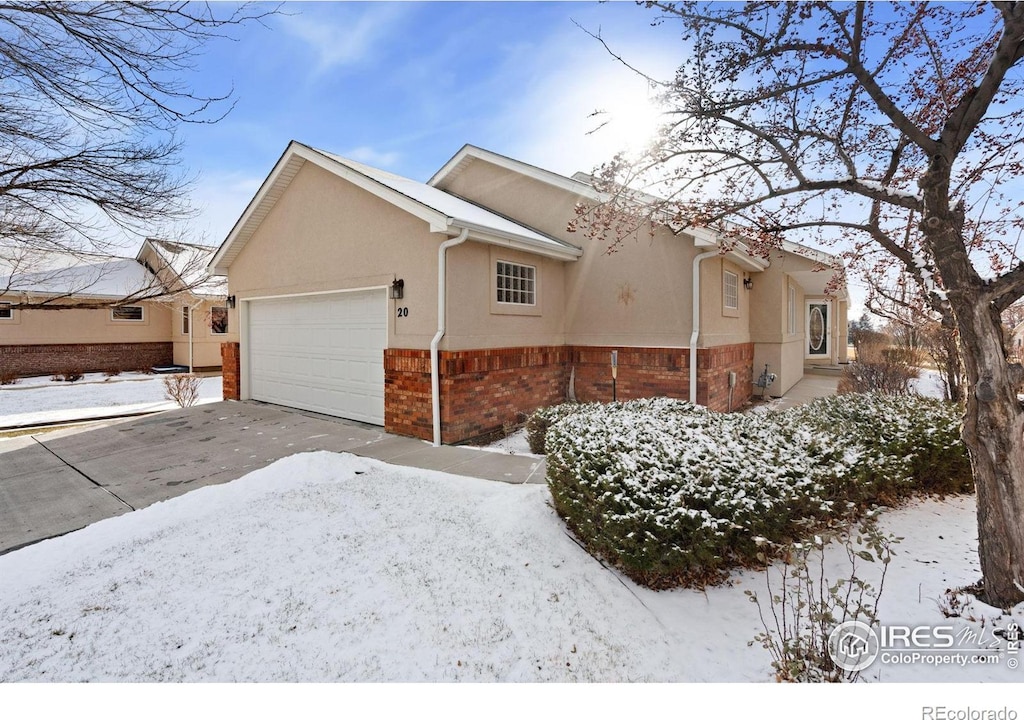 snow covered property with a garage