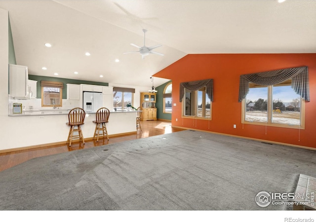 unfurnished living room with ceiling fan and lofted ceiling