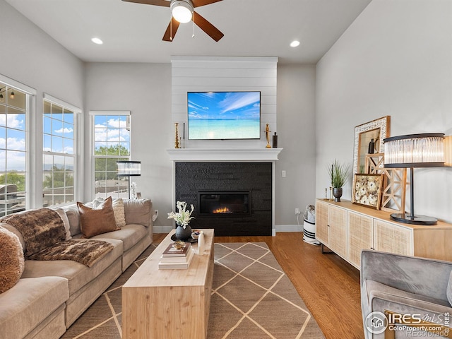 living room with a fireplace, hardwood / wood-style flooring, and ceiling fan