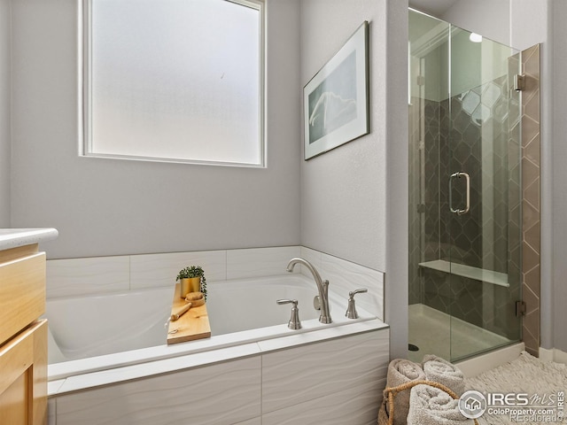 bathroom with vanity, plenty of natural light, and plus walk in shower