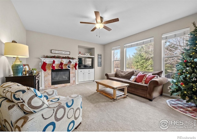 living room featuring a tile fireplace, carpet floors, built in features, and plenty of natural light