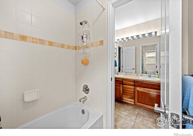 bathroom with tile patterned flooring, vanity, and tiled shower / bath