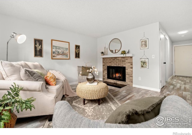 living room with a fireplace, a textured ceiling, and light hardwood / wood-style floors