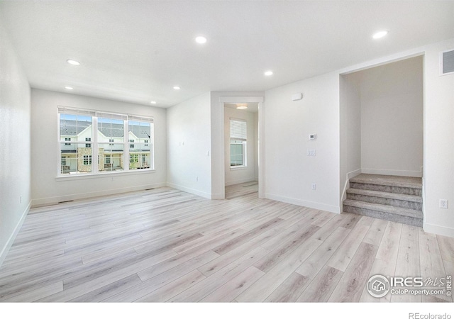 unfurnished living room featuring plenty of natural light and light hardwood / wood-style floors