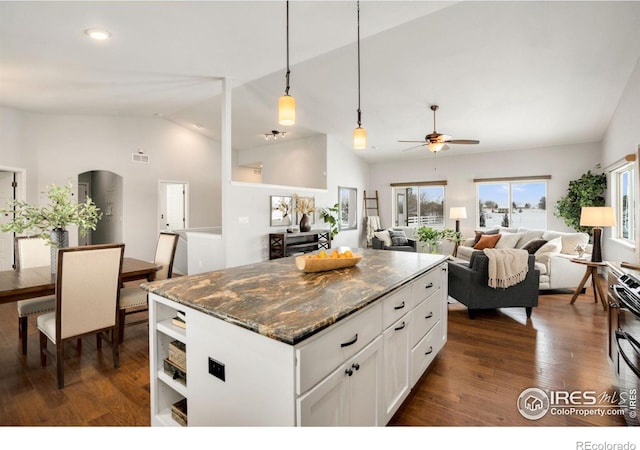 kitchen with white cabinets, dark hardwood / wood-style flooring, dark stone counters, vaulted ceiling, and ceiling fan