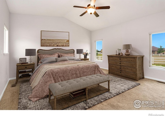 bedroom with ceiling fan, light colored carpet, and vaulted ceiling