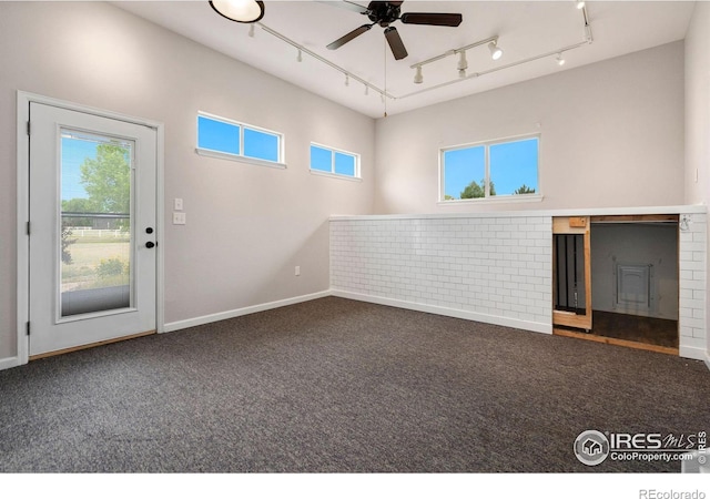 spare room featuring ceiling fan and dark colored carpet