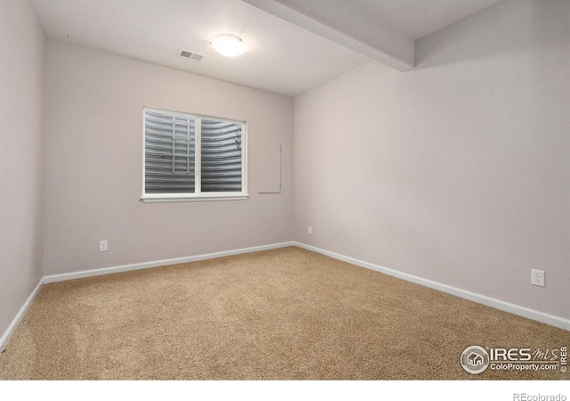 carpeted spare room with beam ceiling