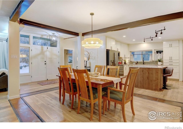 dining area featuring beam ceiling and light hardwood / wood-style floors