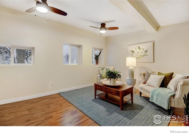 living room featuring beamed ceiling, ceiling fan, and hardwood / wood-style floors