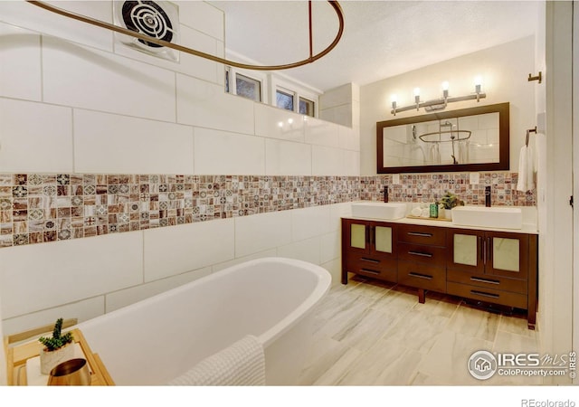 bathroom featuring a washtub, vanity, and tile walls