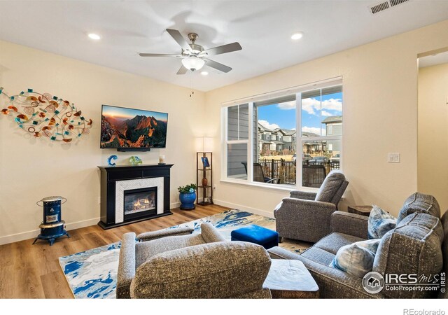 living room featuring hardwood / wood-style floors and ceiling fan