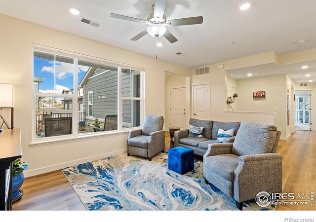 living room with light hardwood / wood-style floors and ceiling fan