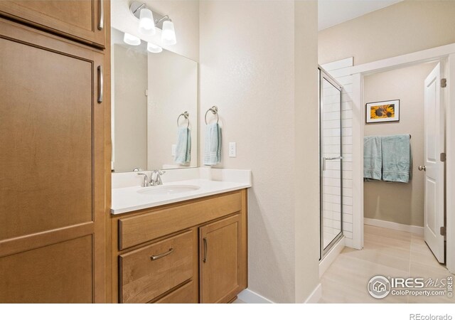 bathroom featuring tile patterned floors, vanity, and a shower with shower door