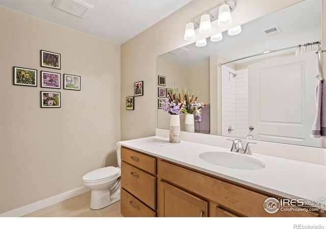 bathroom with tile patterned flooring, vanity, and toilet