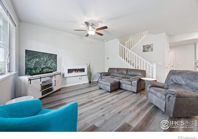 living room featuring wood-type flooring and ceiling fan