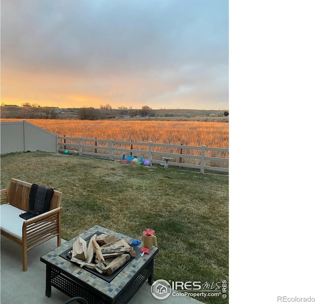 yard at dusk with an outdoor fire pit and a patio area