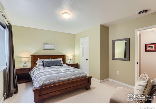 bedroom featuring light colored carpet and a textured ceiling