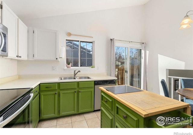 kitchen featuring stainless steel appliances, sink, white cabinets, green cabinets, and light tile patterned flooring