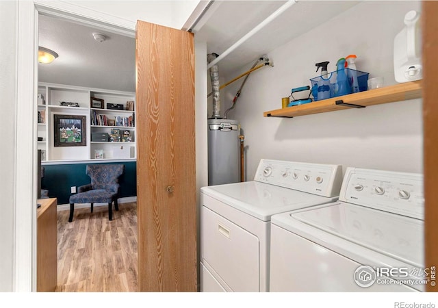 washroom featuring water heater, light hardwood / wood-style flooring, and washer and dryer