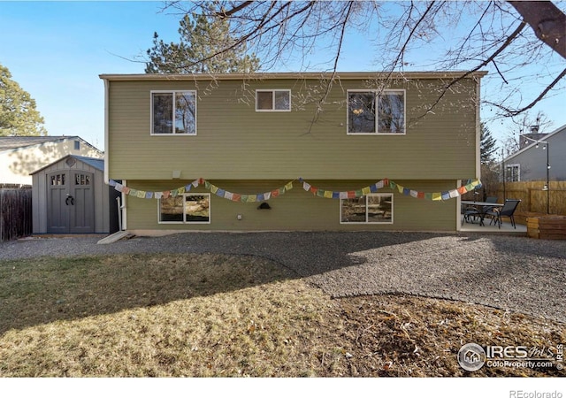 rear view of house with a storage unit and a patio