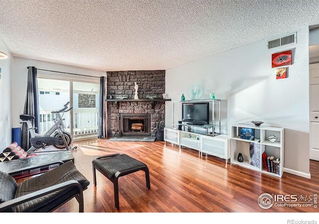 living room featuring a fireplace, hardwood / wood-style floors, and a textured ceiling