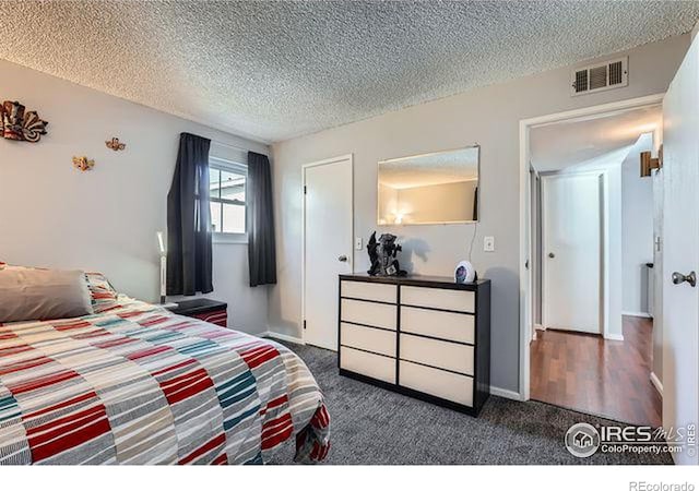 carpeted bedroom featuring a textured ceiling