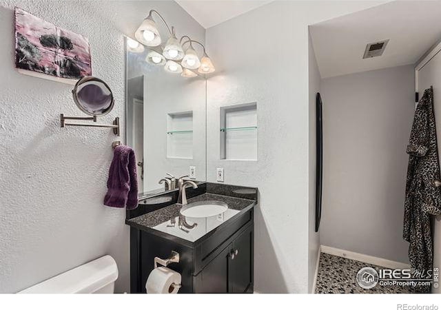 bathroom featuring tile patterned floors, vanity, and toilet