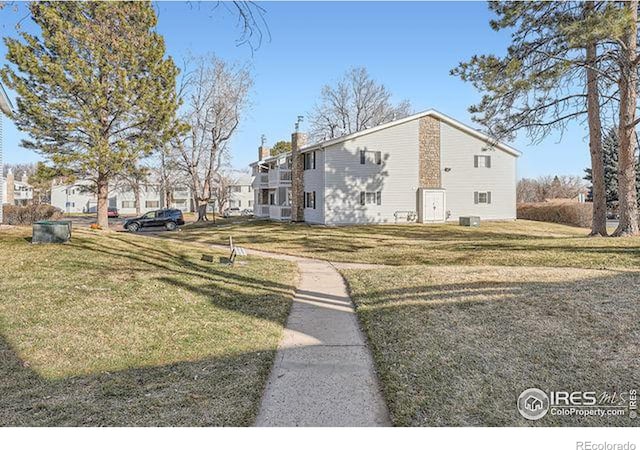 exterior space featuring a yard and central AC