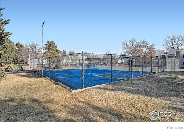 view of sport court with a yard