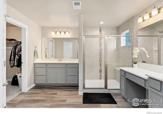 bathroom with a shower with door, vanity, and hardwood / wood-style flooring