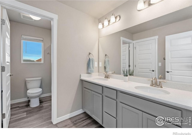 bathroom with hardwood / wood-style flooring, vanity, and toilet