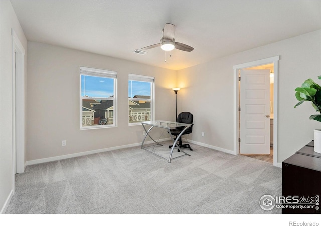 carpeted office space with ceiling fan