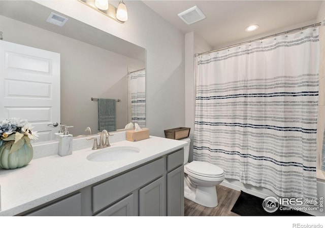 bathroom with vanity, hardwood / wood-style flooring, a shower with curtain, and toilet