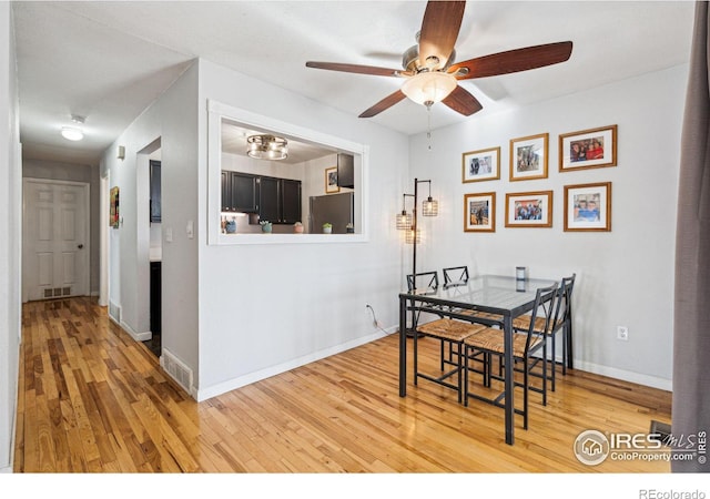 dining space with ceiling fan and wood-type flooring