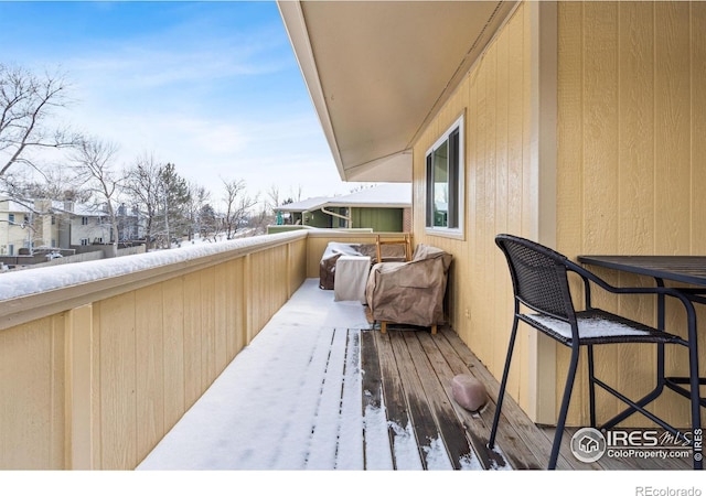 view of snow covered back of property