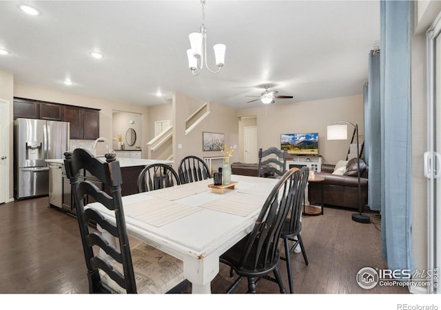 dining space featuring ceiling fan with notable chandelier and dark wood-type flooring