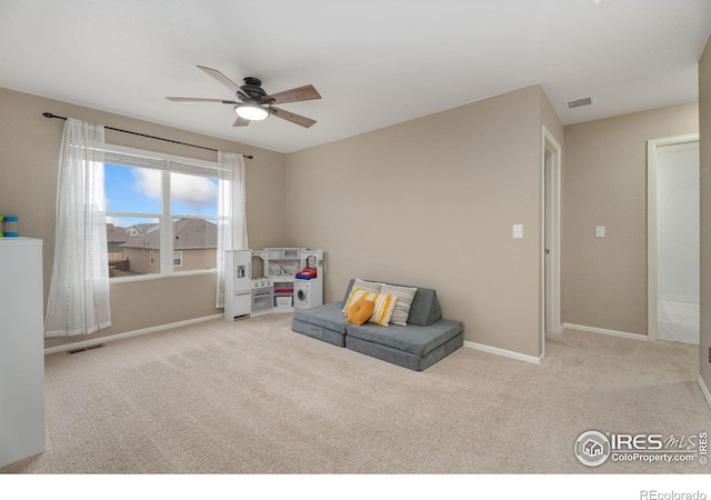 sitting room featuring ceiling fan and light colored carpet