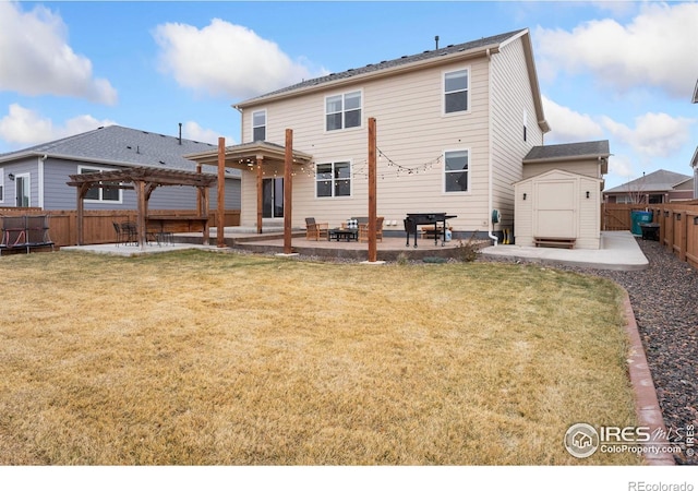 rear view of property with a pergola, a patio area, a yard, and a shed