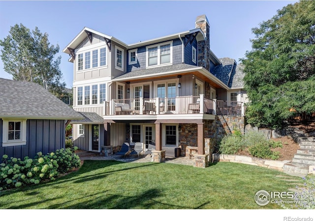 back of property featuring a balcony, a yard, and a patio