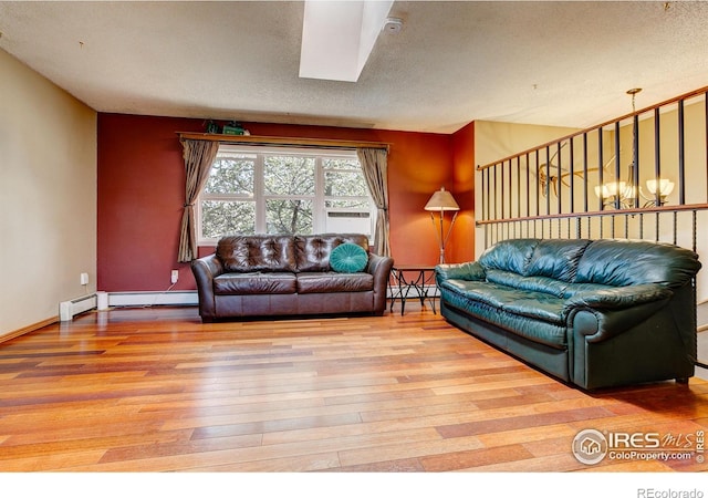 living room featuring a skylight, hardwood / wood-style floors, and a baseboard radiator